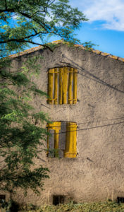 Old house with yellow shutters in Montady at Beziers Old house with yellow shutters in Montady at Beziers